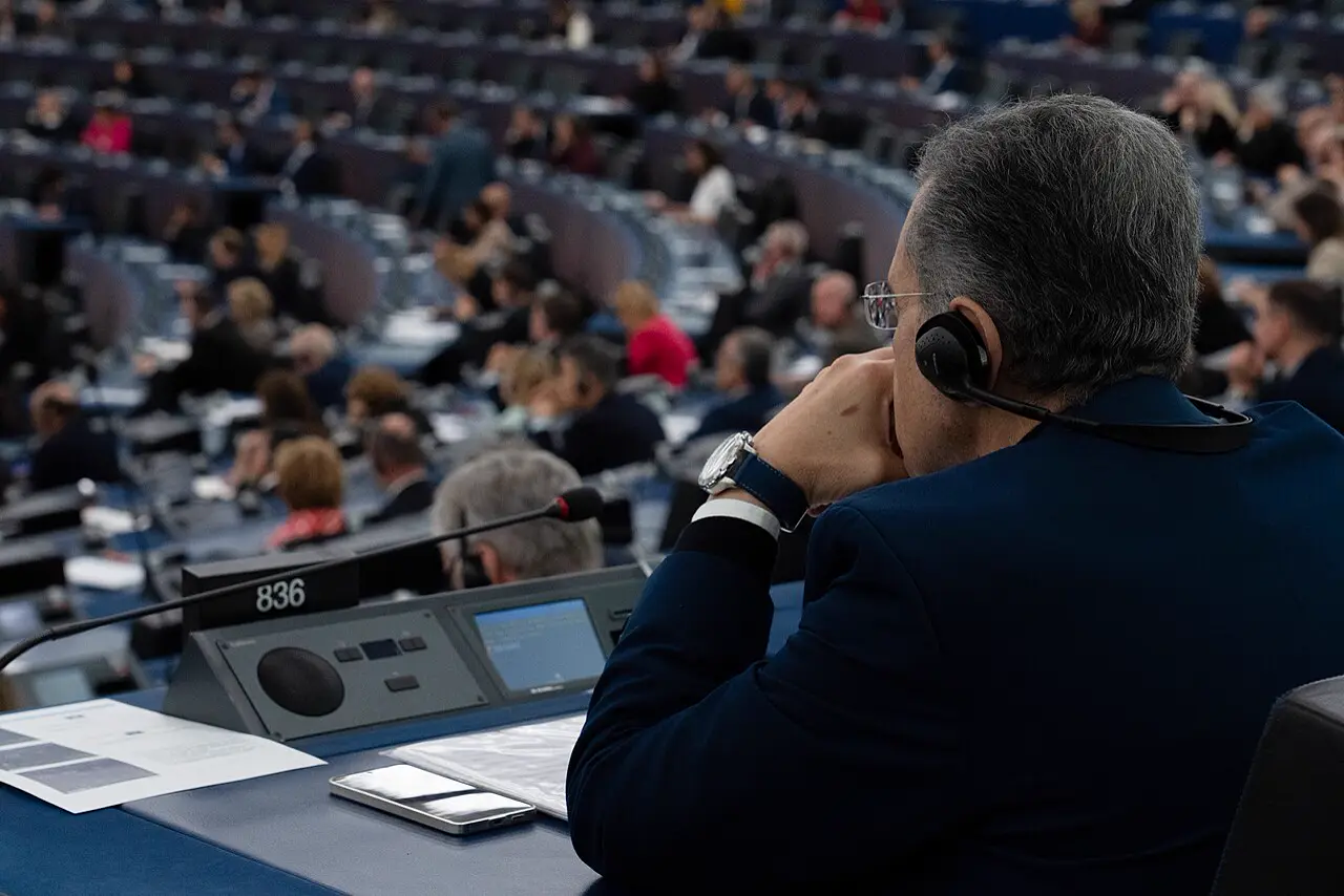 Abgeordneter mit Kopfhörer im Plenarsaal des Europäischen Parlaments
