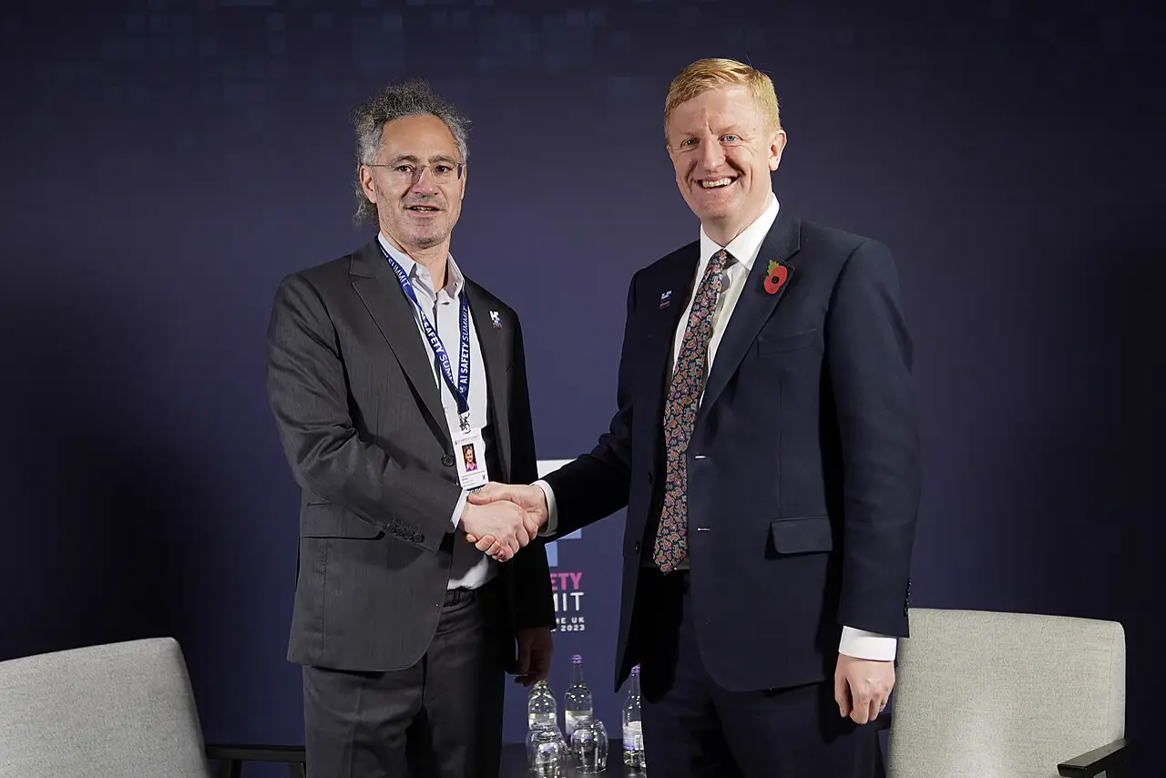 Alex Karp and Oliver Dowden shaking hands