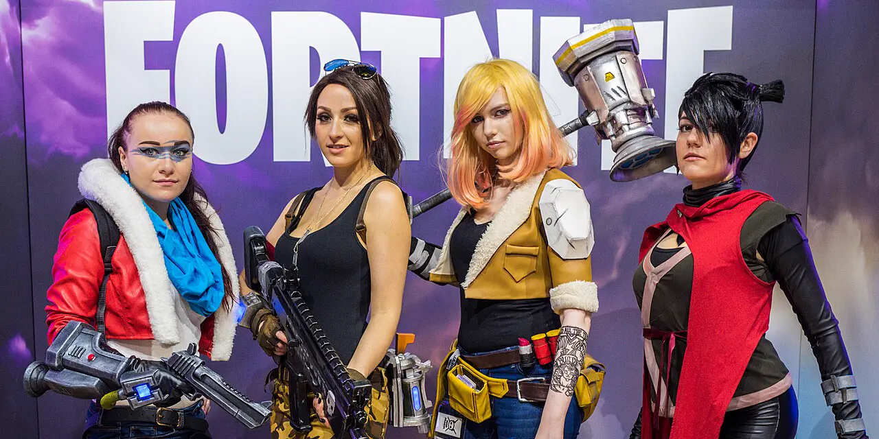 Vier Cosplayerinnen in Fortnite-Kostümen vor dem Fortnite-Schriftzug