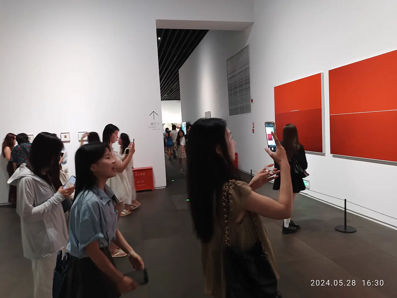 Besucherinnen fotografieren in einem Museum mit Smartphones