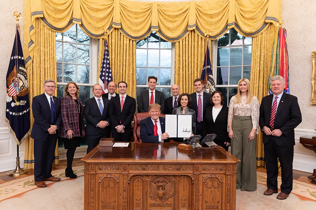 Donald Trump am Schreibtisch im Oval Office mit Gästen