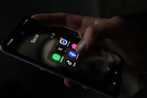 Hand hält ein Smartphone mit WhatsApp, Facebook und weiteren sozialen Apps