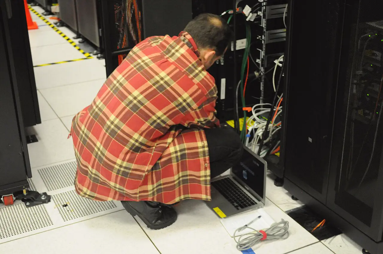 Technician with a laptop at a server rack